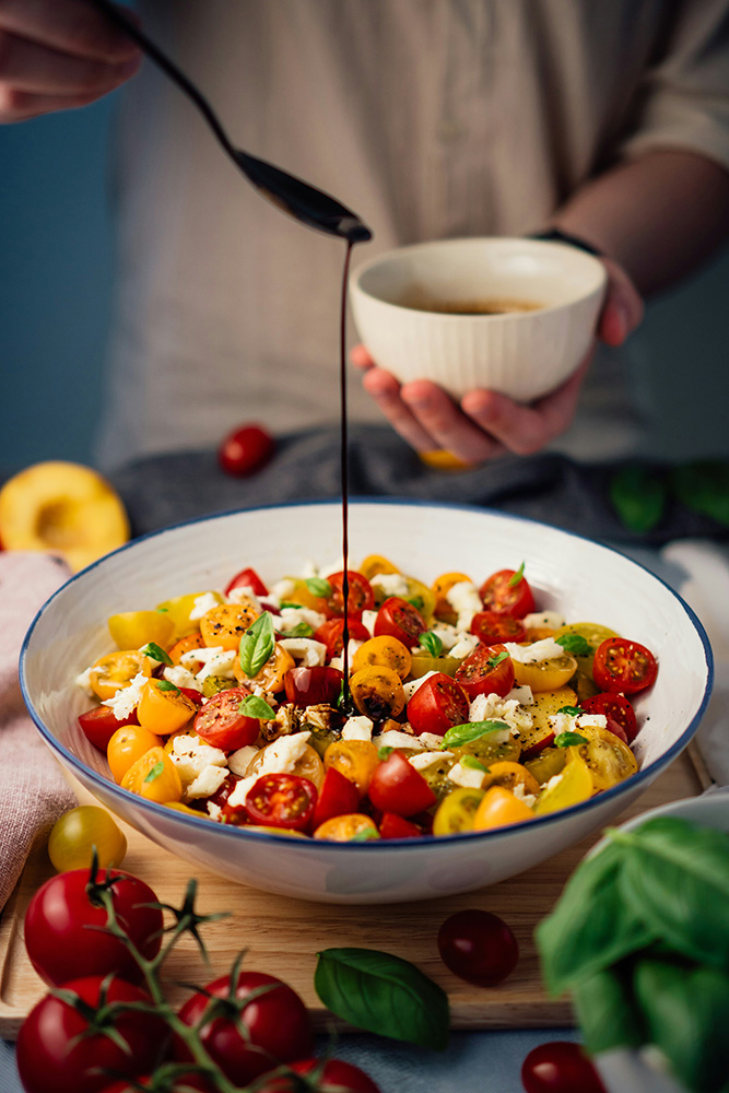 Fresh tomato salad with balsamic dressing being prepared
